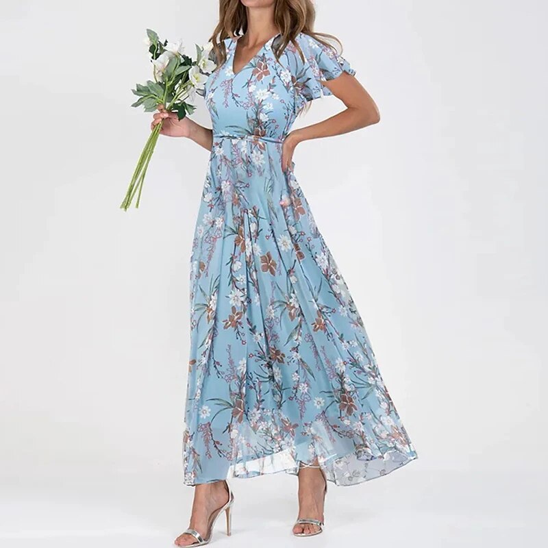 
                  
                    Elvianne – Lange Zomerjurk met Levendige Bloemenprint - SkinzLine
                  
                