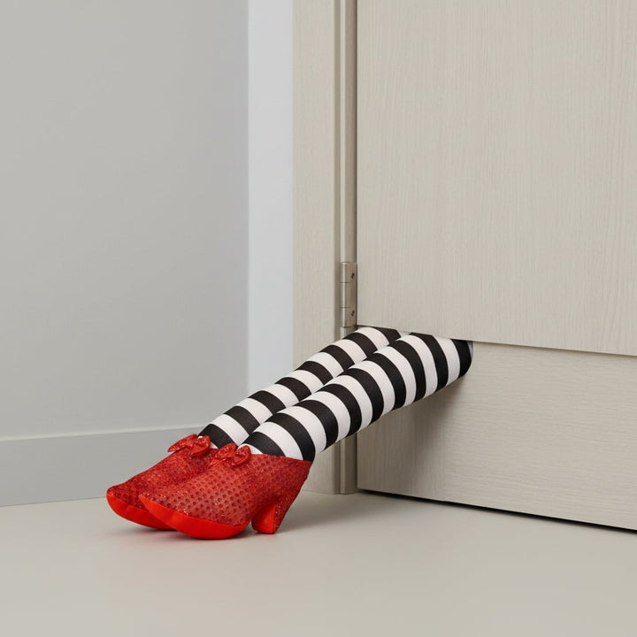 Halloween heksenbenen deurstopper decoratie met gestreepte kousen en rode schoenen